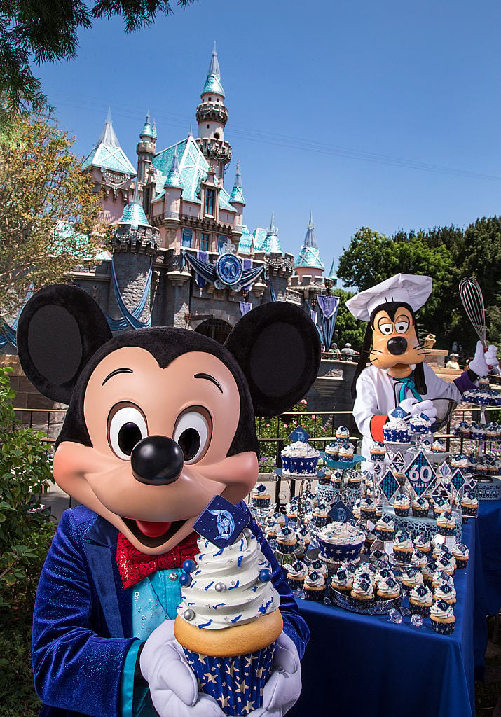 Mickey Mouse and Goofy help prepare celebratory cupcakes at Disneyland.