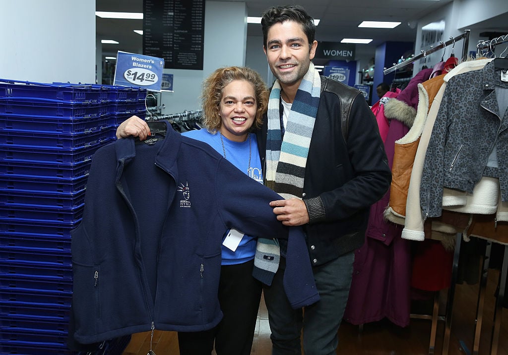 two goodwill employees show off a jacket two goodwill employees show off a jacket