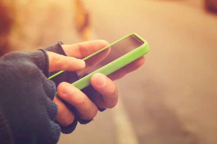 Man with gloves using cellphone outdoors
