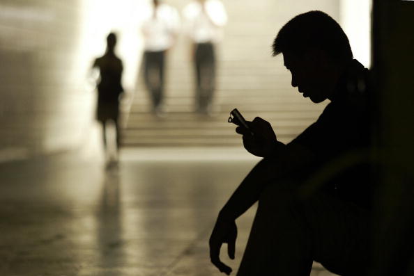 a silhouette of a boy checking his cell phone a silhouette of a boy checking his cell phone