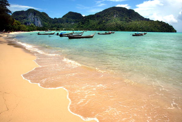 the beach in thailand with long boats and mountains a beach in thailand with long boats and mountains