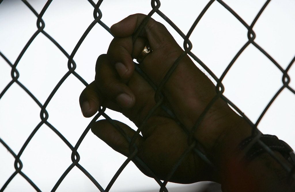 An inmate holds onto a fence in Angola prison An inmate holds onto a fence in Angola prison