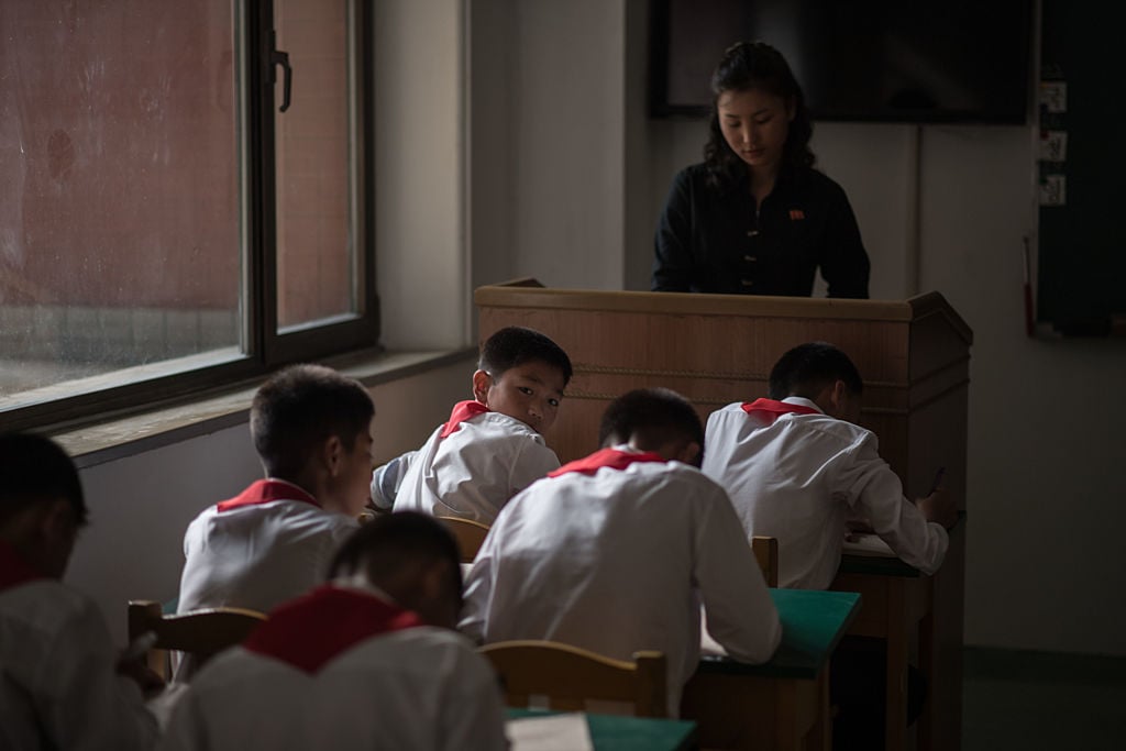 Students of the Pyongyang International Football School sit inside a classroom as they take a test.