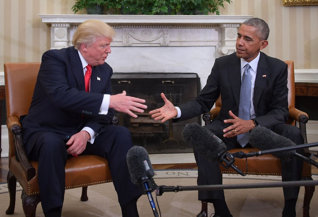 Barack Obama and Donald Trump shake hands in the Oval Office.