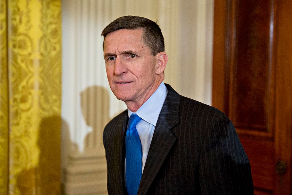 michael flynn in a dark suit and blue tie against white columns michael flynn in a dark suit and blue tie against white columns