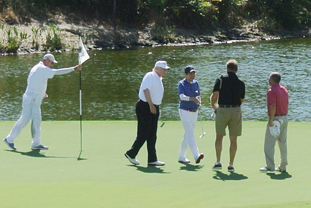 Trump golfs with Japan's Prime Minister Shinzo Abe (center)