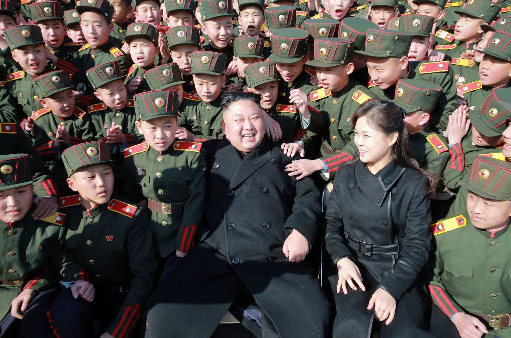 Kim Jong Un sits with students.
