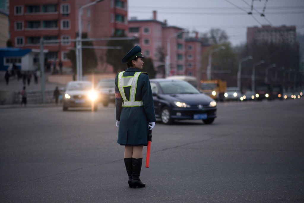 a woman in uniform directs traffic in north korea a woman in uniform directs traffic in north korea
