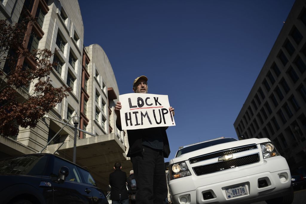 a man holds a protest sign outside the court where flynn testified a man holds a protest sign outside the court where flynn testified
