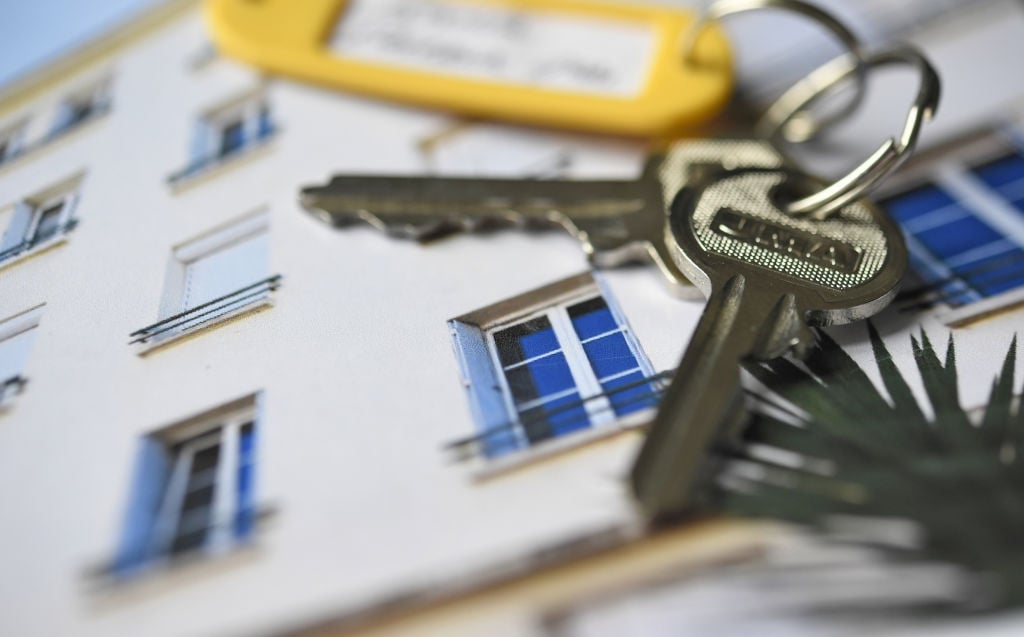 a pair of keys rests on a photo of a house a pair of keys rests on a photo of a house