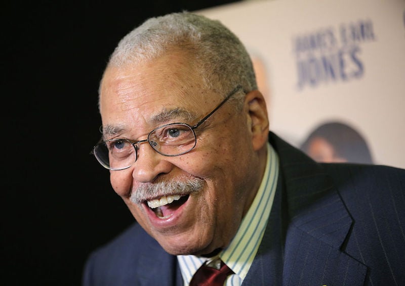 James Earl Jones smiling while wearing a suit and glasses James Earl Jones smiling while wearing a suit and glasses