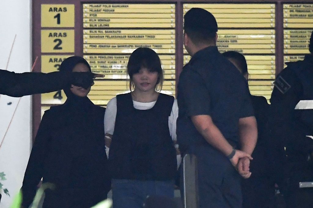Royal Malaysian Police escort Vietnamese defendant Doan Thi Huong (2nd L) after her trial at the Shah Alam High Court in Shah Alam