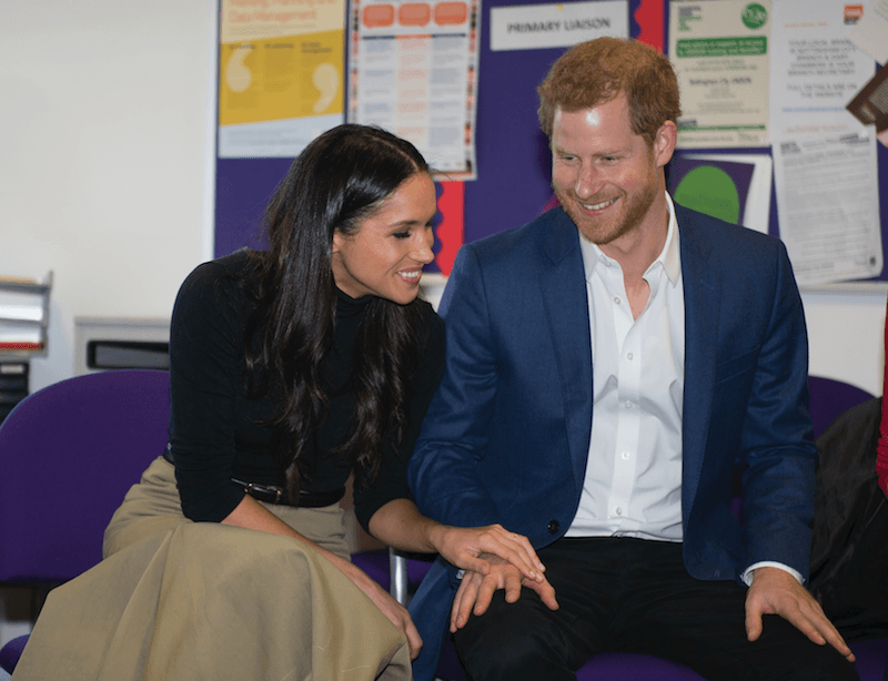 Meghan Markle and Prince Harry sit next to each other