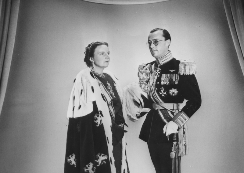 Prince Bernhard and Princess Juliana stand in front of a wall. Prince Bernhard and Princess Juliana stand in front of a wall.