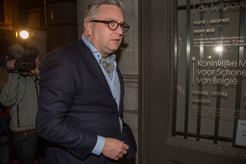 Prince Laurent stands in glasses wearing a blue suit. Prince Laurent stands in glasses wearing a blue suit.