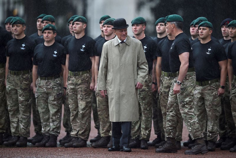 Prince Phillip stands in front of a group of young soldiers. 