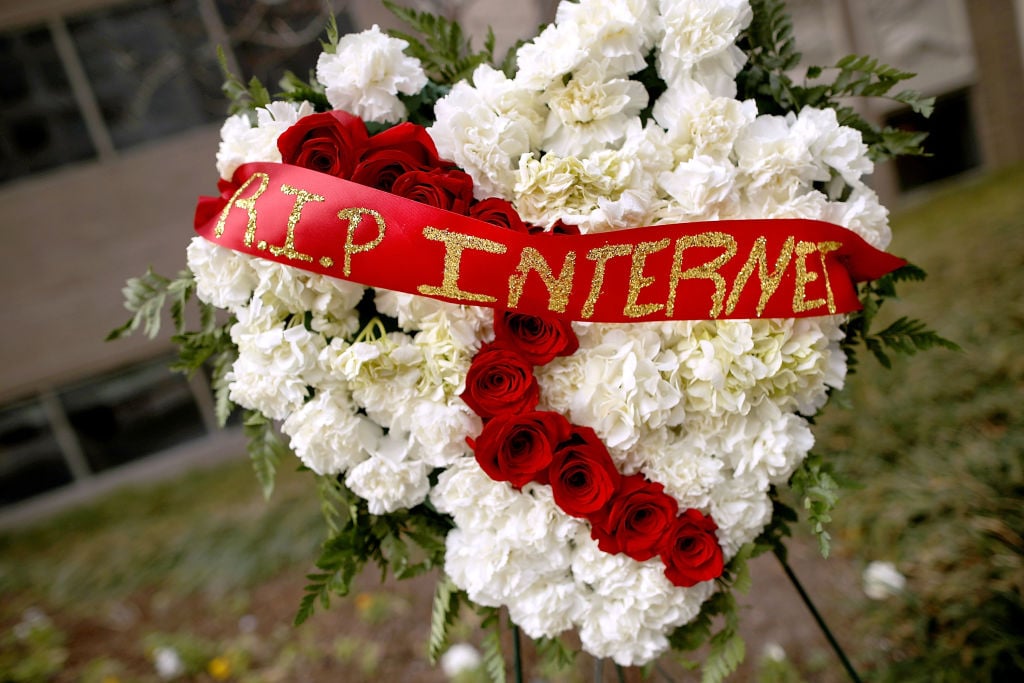 A funeral flower arrangement is set up outside the Federal Communication Commission building