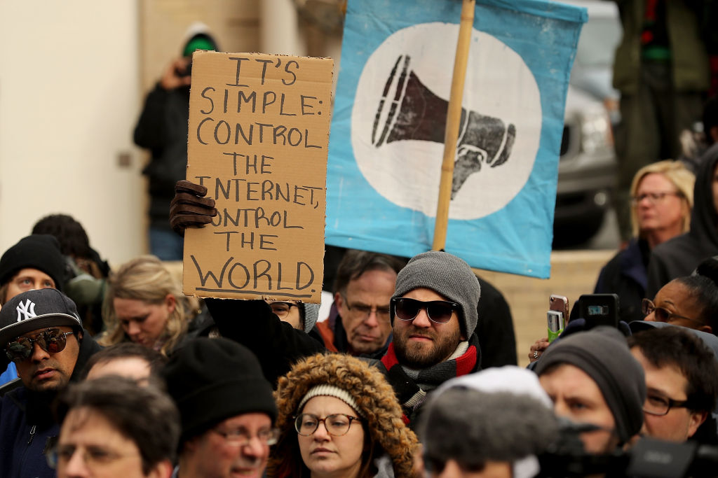 protestors hold a sign protesting mass surveillance outside the US capitol Demonstrators rally outside the Federal Communication Commission building to protest against the end of net neutrality rules