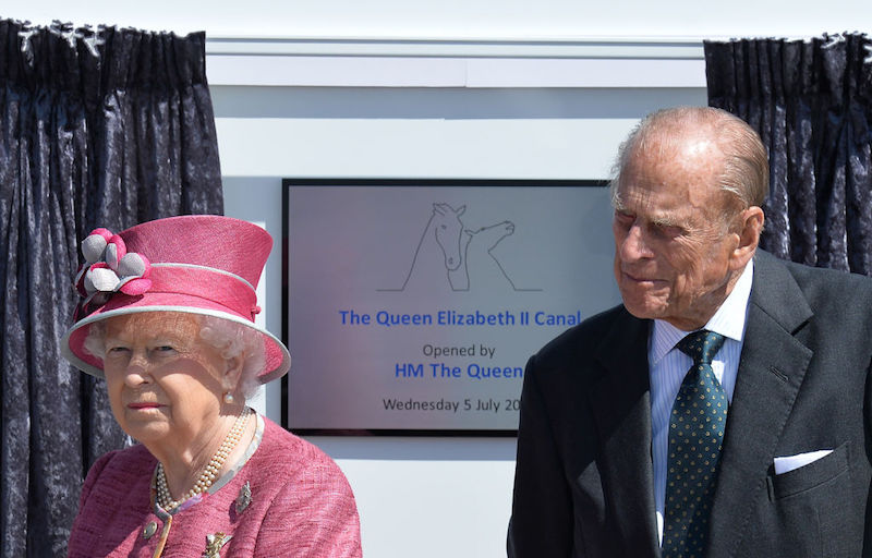 Prince Phillip standing next to Queen Elizabeth. 