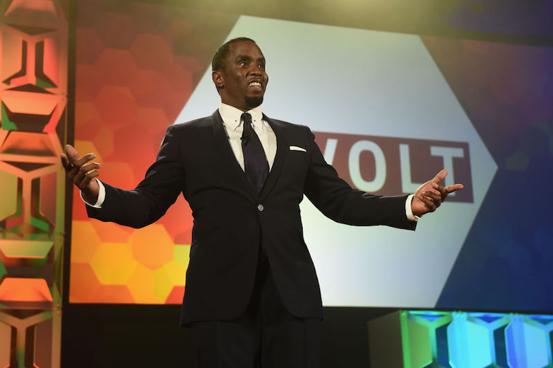 Sean Combs addresses an audience in a black suit. Sean Combs addresses an audience in a black suit.