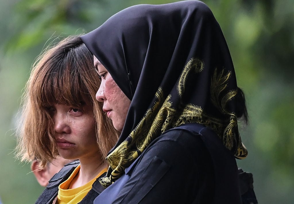 Vietnamese national Doan Thi Huong (L), 28, is escorted with a heavy police presence