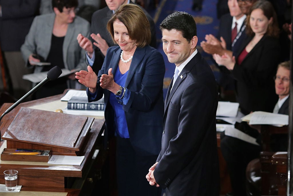 Speaker-elect of the House Paul Ryan and Minority Leader Nancy Pelosi applaud on the floor of the House chamber