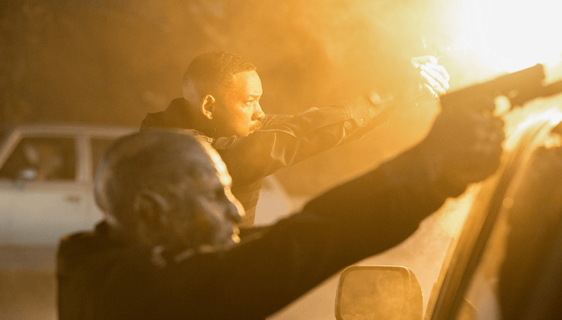 Will Smith and an alien aiming their weapons. Will Smith and an alien aiming their weapons.