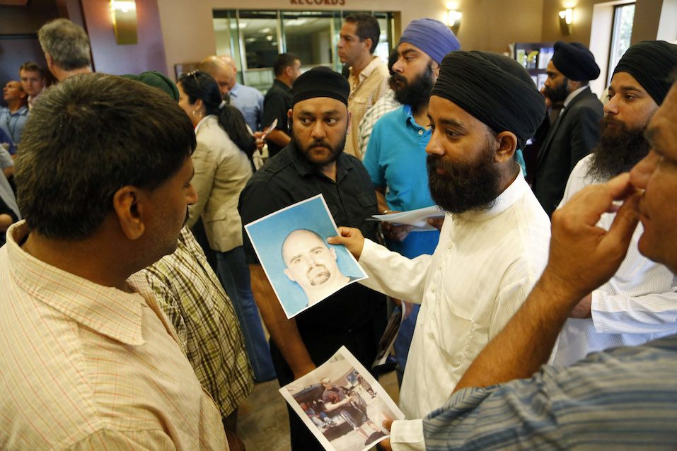 Wisconsin Community Reels After Gunman Kills Six At Sikh Temple Members of the community hold up the mug shot handed out by the FBI of the suspected shooter Wade Michael Page