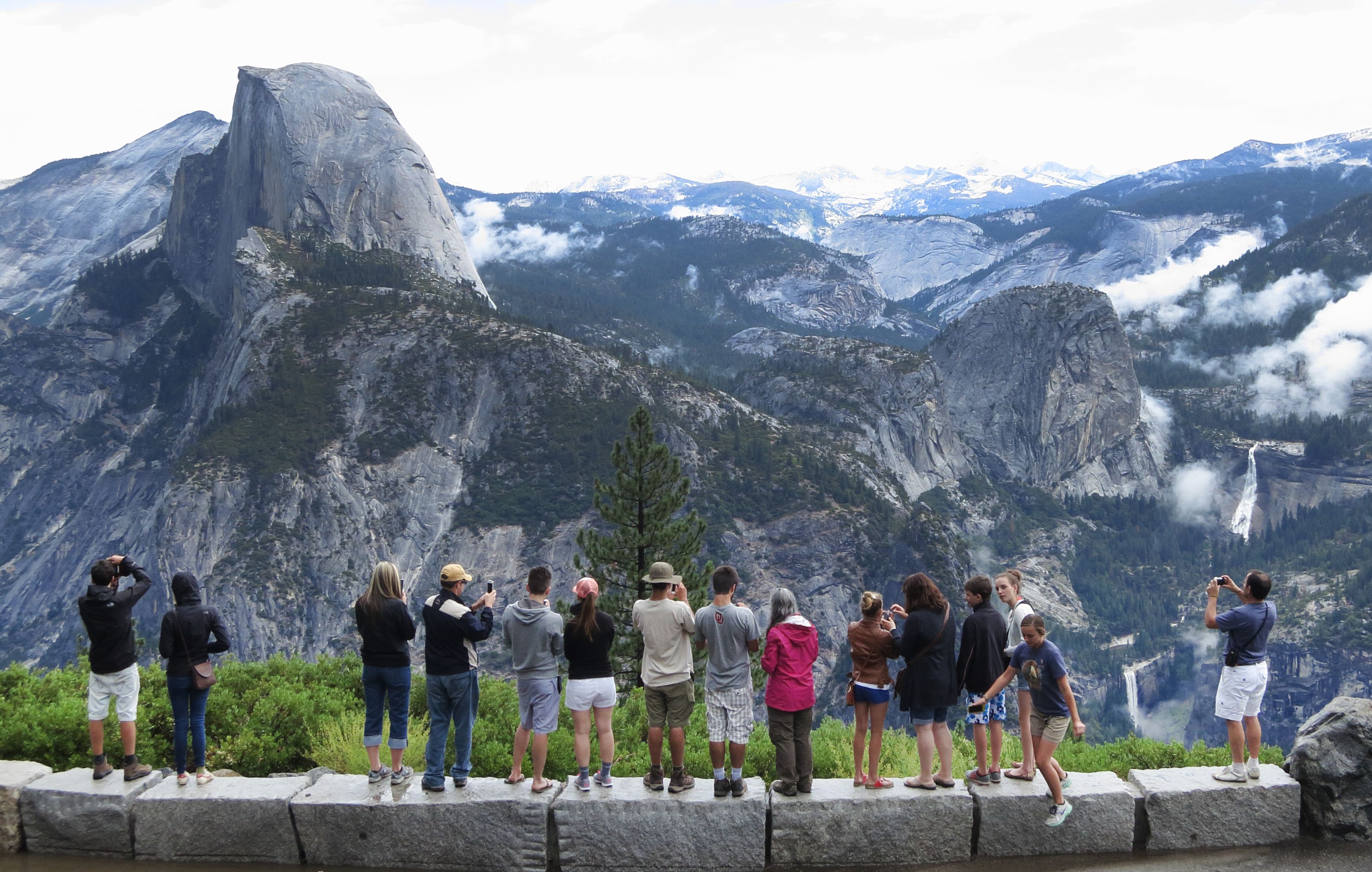 Visitors look out at Yosemite National Park from Glacier Point