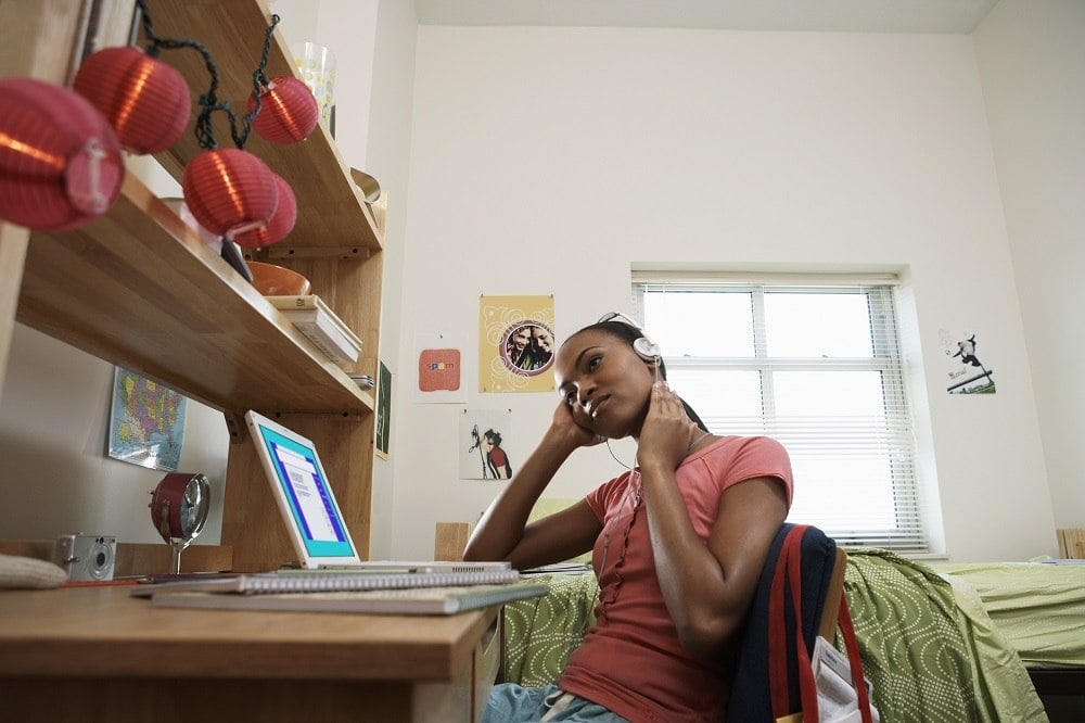 woman sitting at desk, wearing headphones