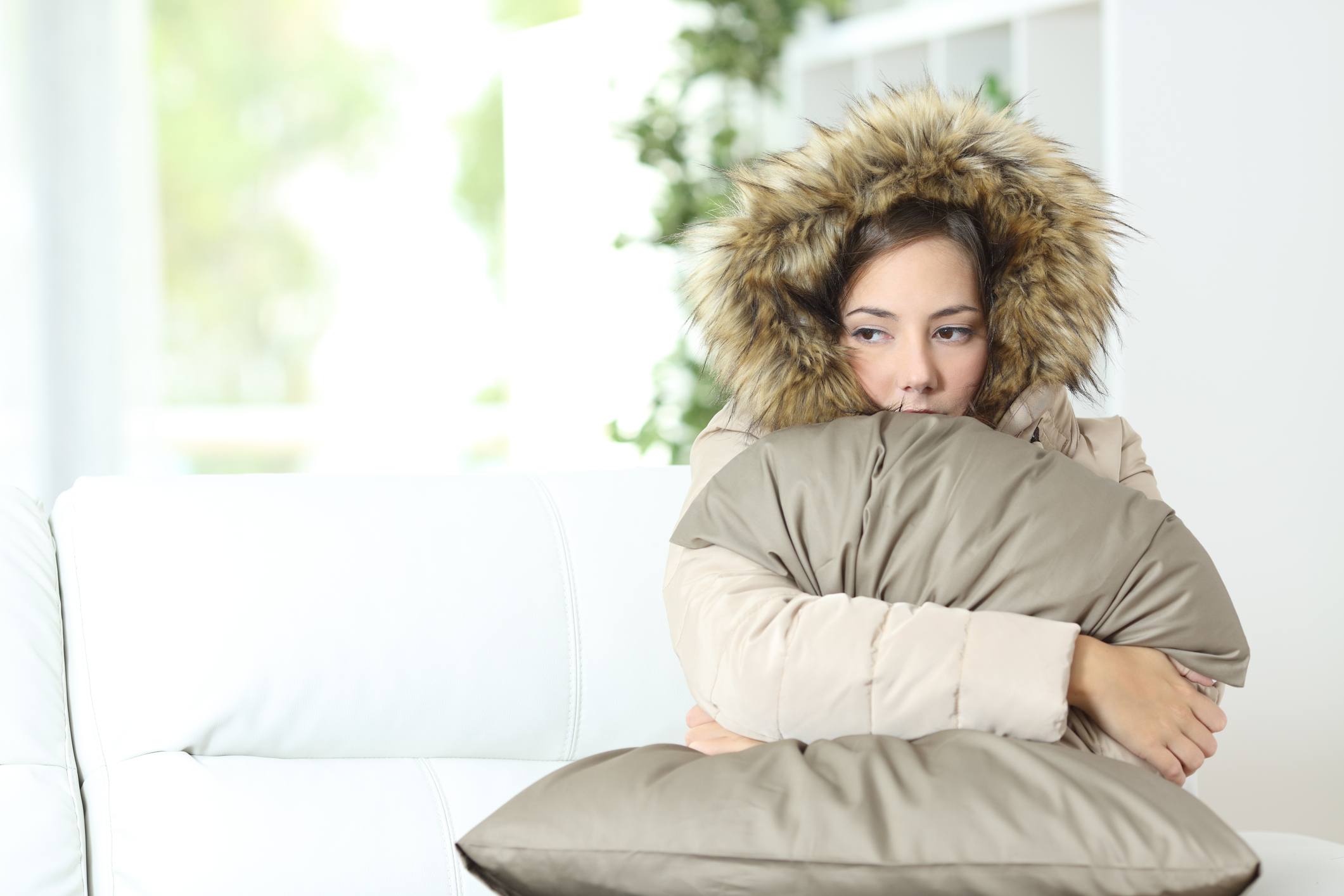 Cold Woman warmly clothed in a cold home