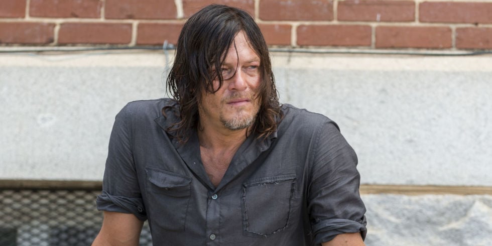 Daryl sits in front of a brick wall