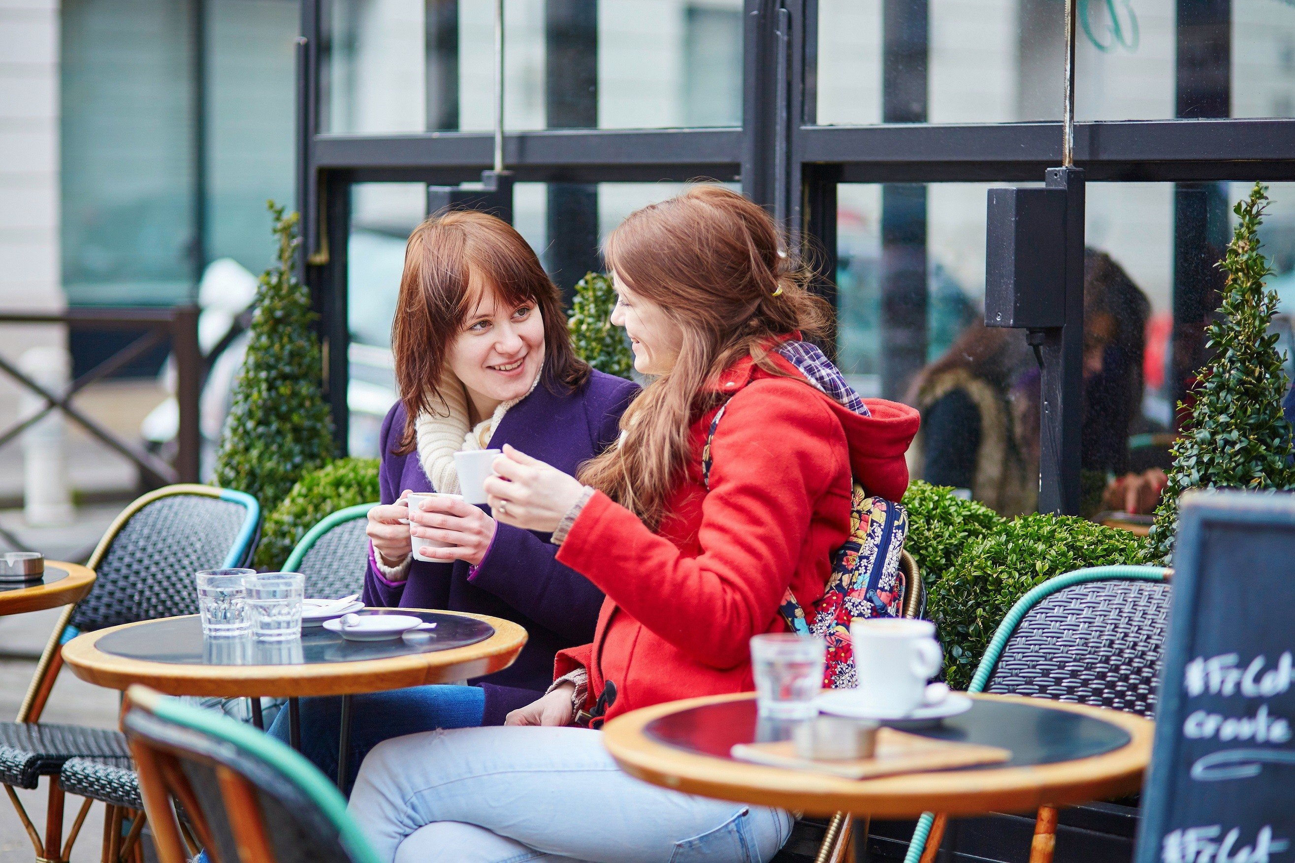 Two women sitting at a cafe table in Paris