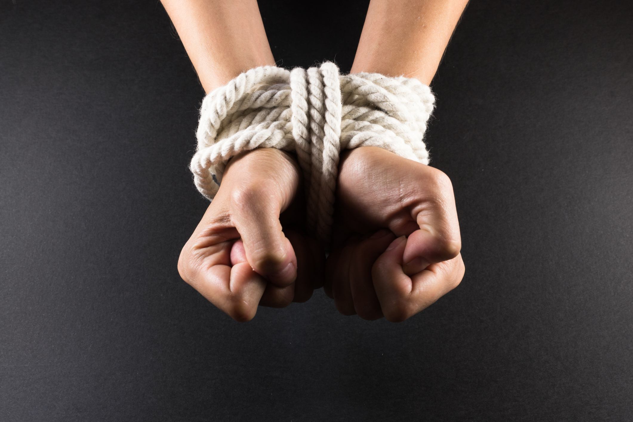 White hands bound with rope