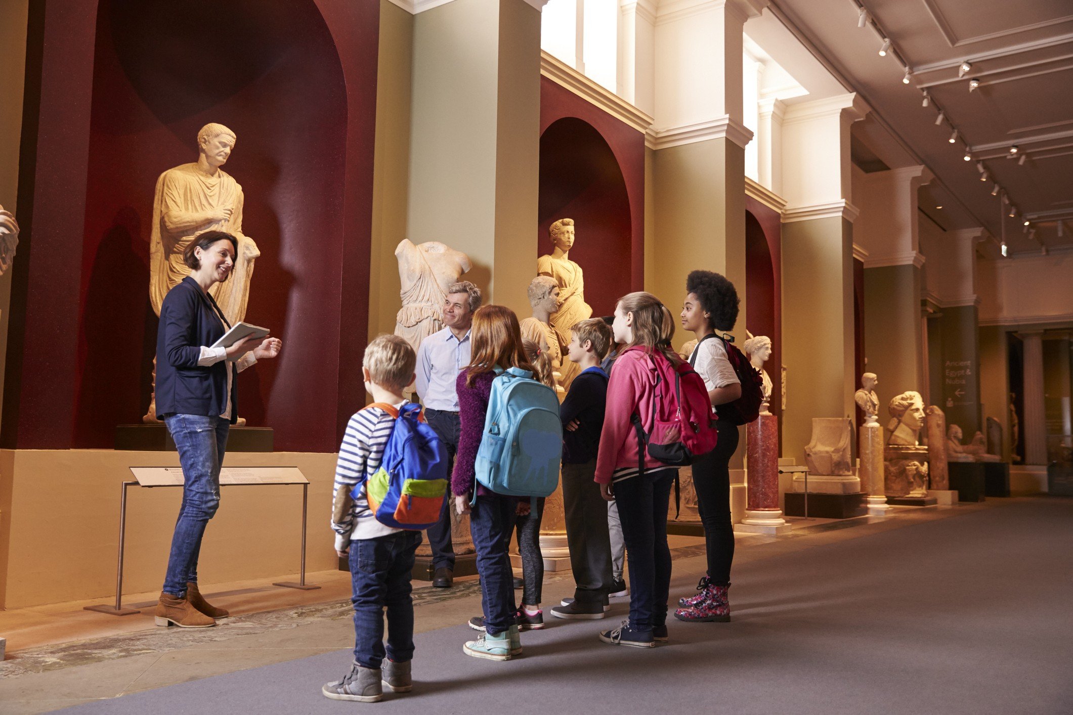 Children and tour guide discuss museum