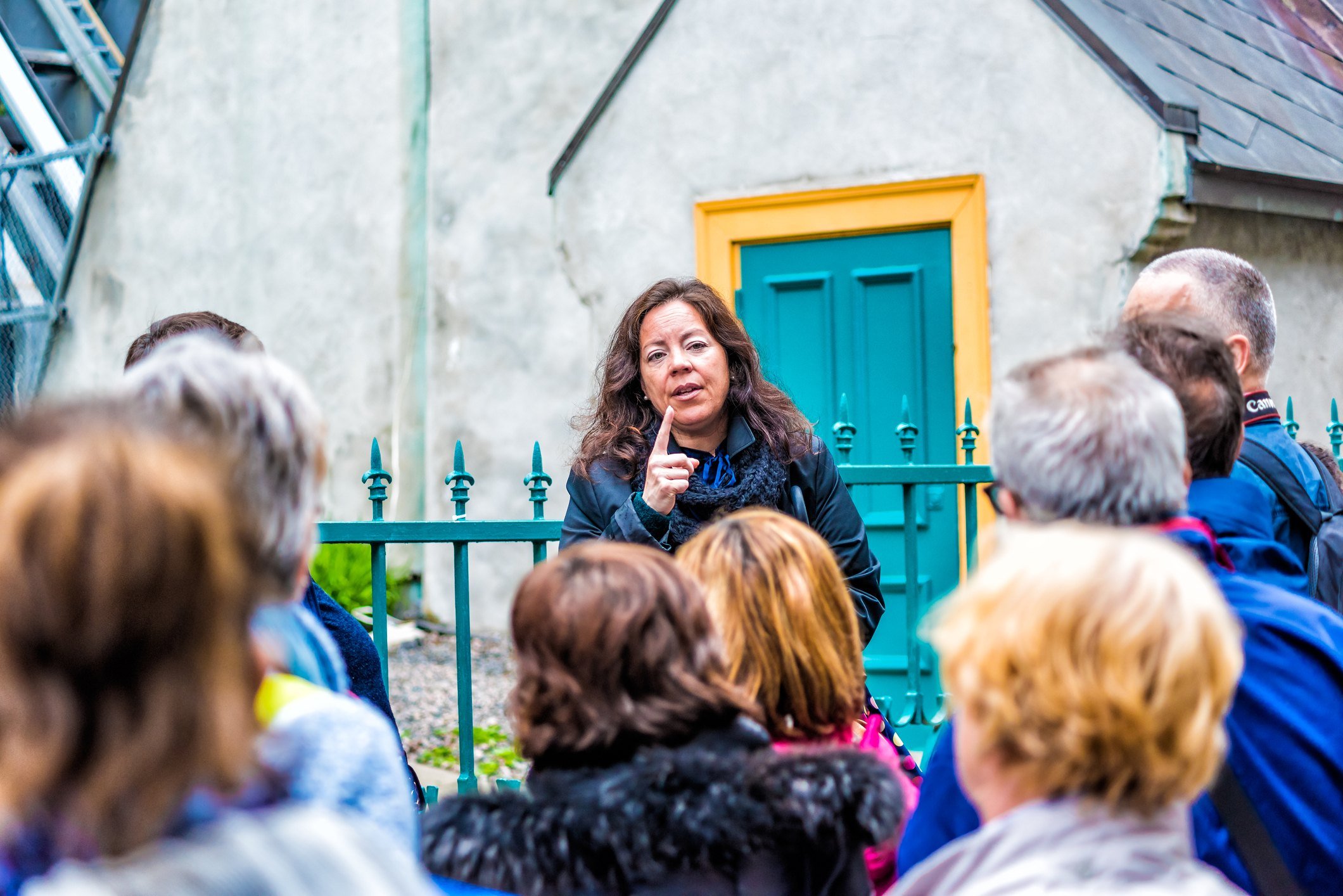 Tour guide speaking to group in front of blue door