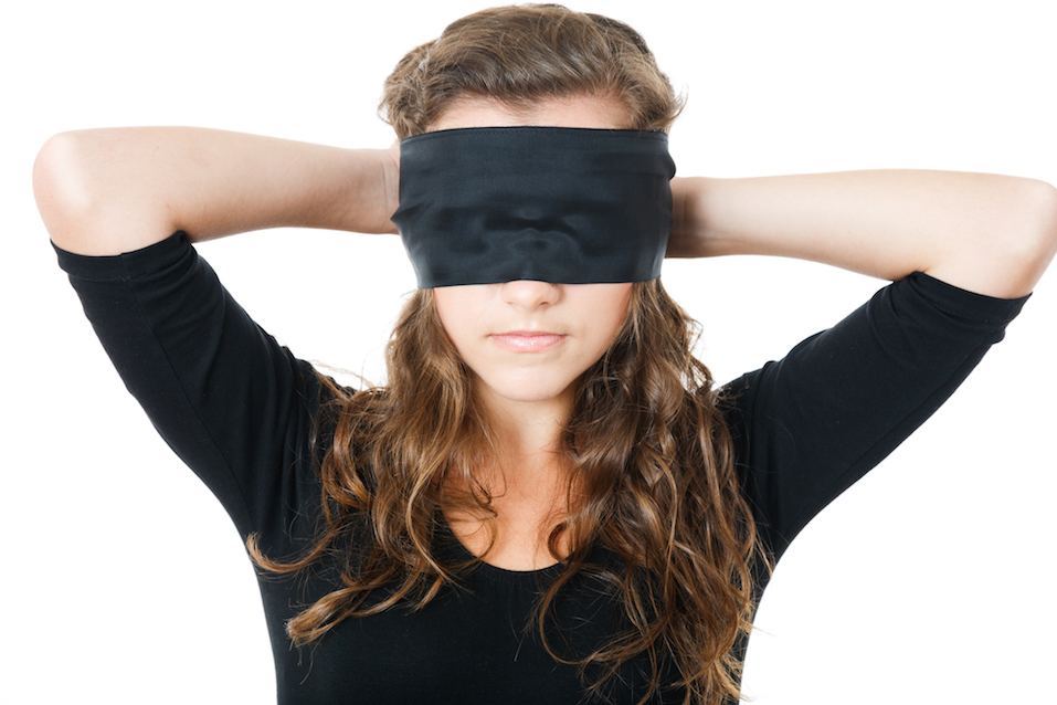 Female tie her eyes with black ribbon
