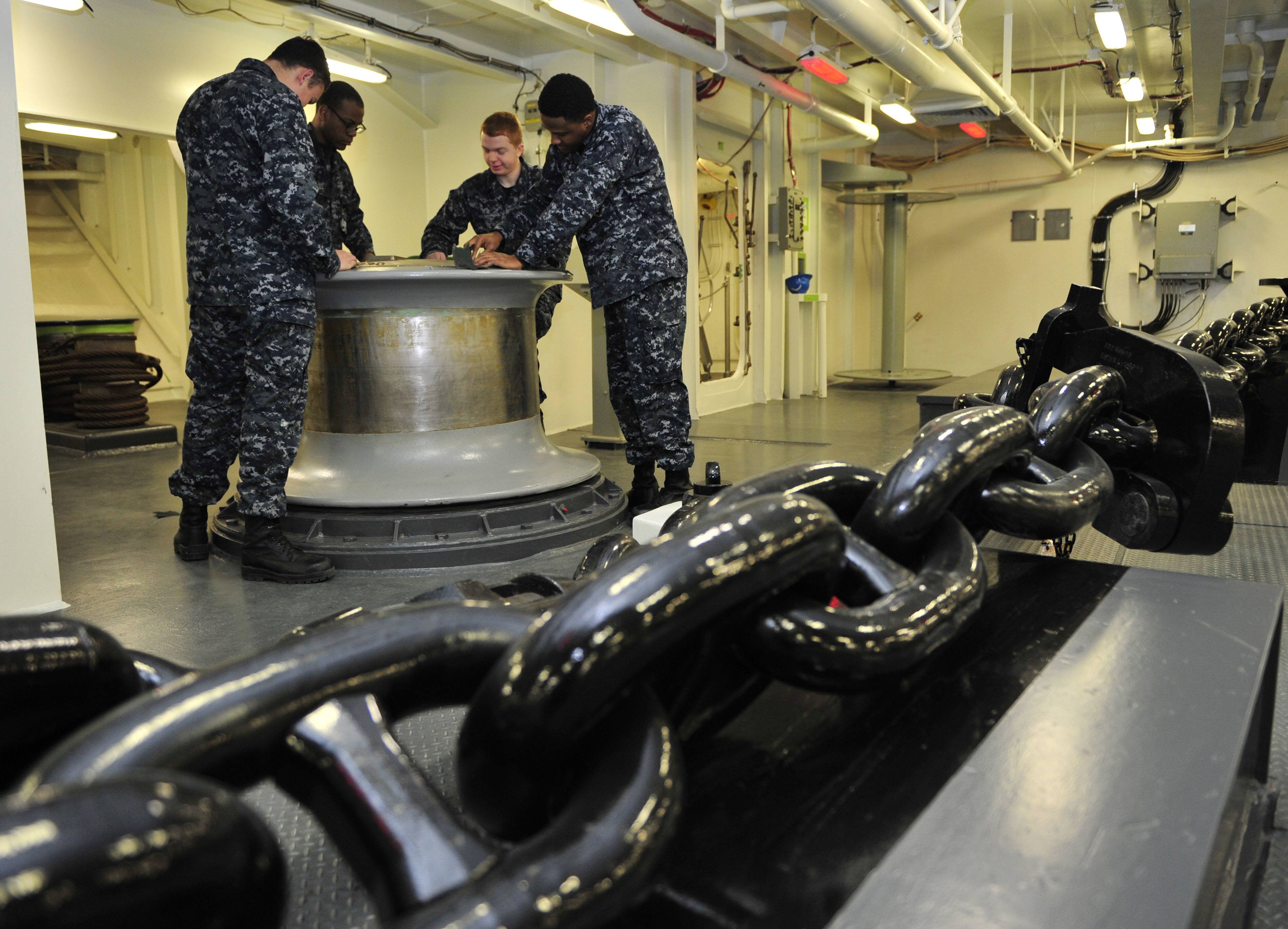 Deck Department Sailors assigned to Pre-Commissioning Unit Gerald R. Ford (CVN 78), polish the capstone inside the ship's forecastle. 