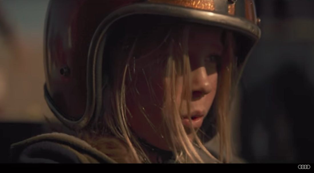A young girl in a racing helmet. A young girl in a racing helmet.