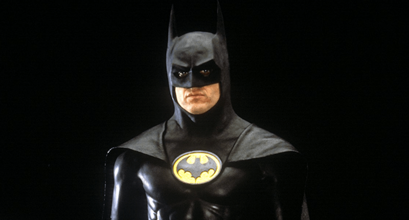 Batman standing in front of a black background. 