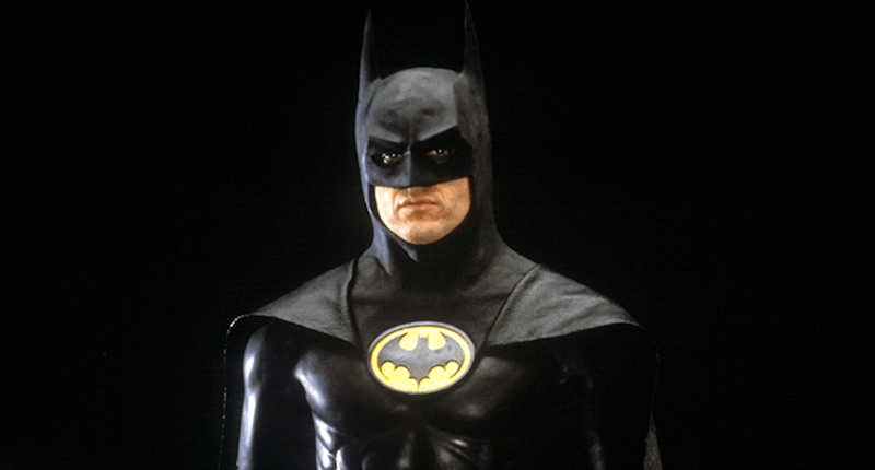 Batman standing in front of a black background. Batman standing in front of a black background.