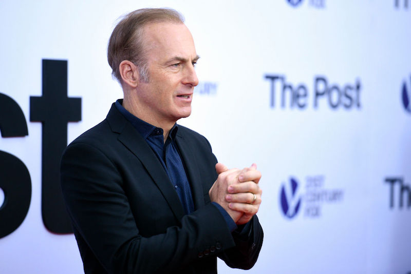 Bob Odenkirk posing on a red carpet while holding his hands. Bob Odenkirk posing on a red carpet while holding his hands.