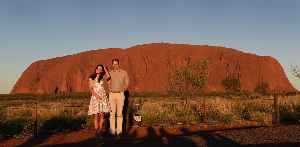 Prince William (R) and his wife Catherine, the Duchess of Cambridge, stand in front of Uluru