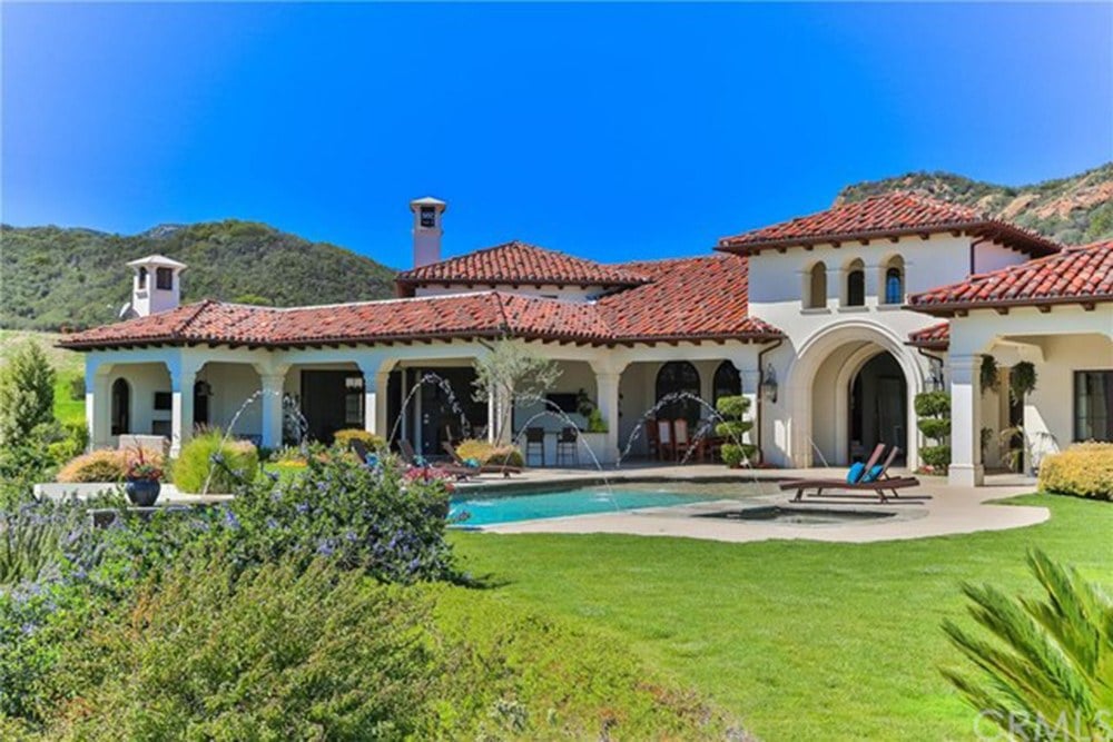 Back of Spanish style home with pool