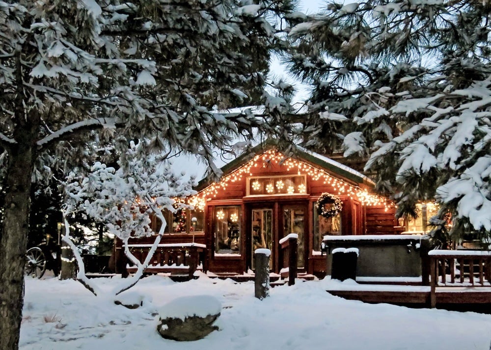 Christmas lights on wooden cabin in mountains Christmas lights on wooden cabin