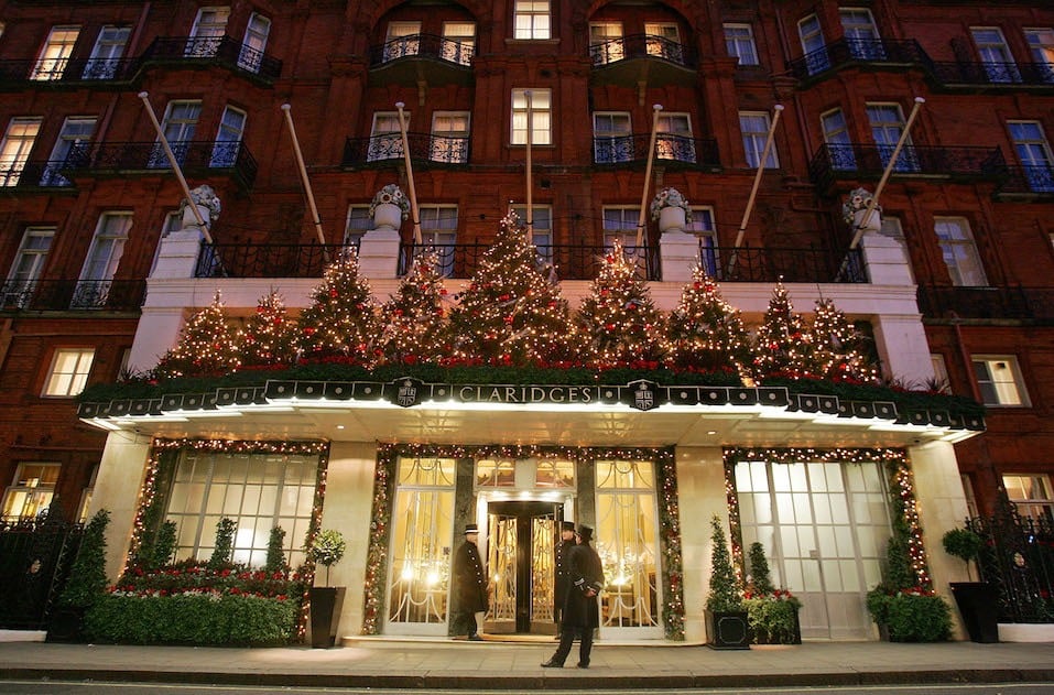 Doormen stand on duty in front of Claridge's Hotel which is lit up for Christmas