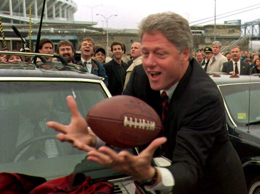 Democratic presidential candidate Bill Clinton catches a football