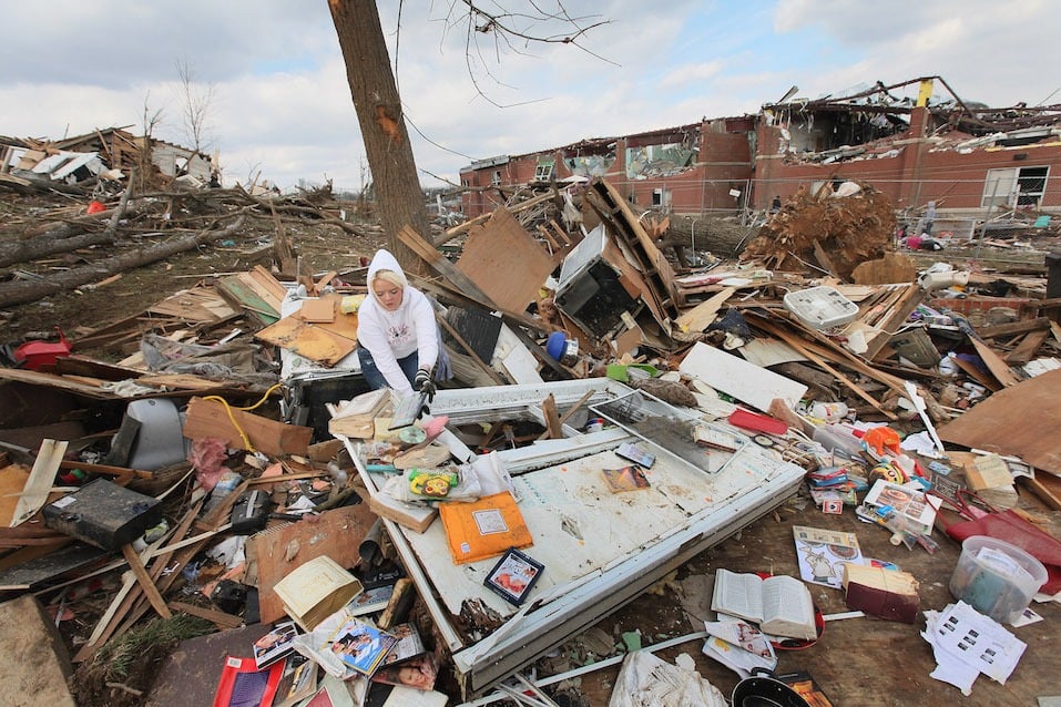 Lori Hall searches for items to salvage in the home of her aunt and uncle after it was destroyed by Friday's EF-4 tornado
