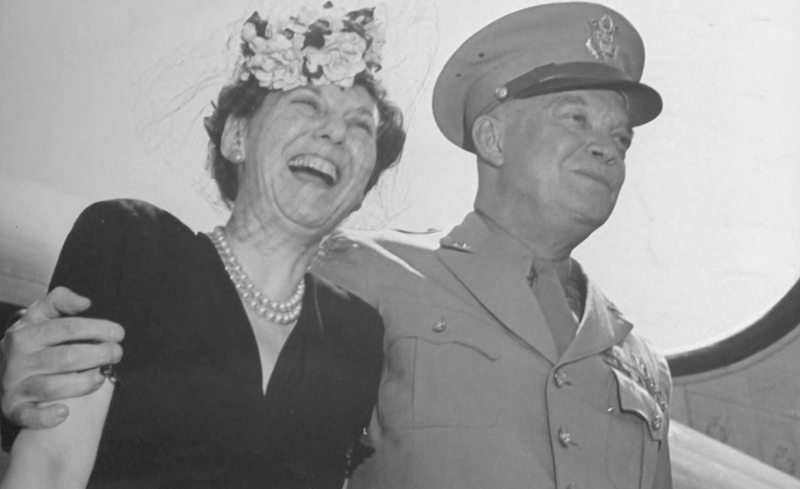 Mamie Eisenhower and Dwight D. Eisenhower smiling and posing in front of photographers. Mamie Eisenhower and Dwight D. Eisenhower smiling and posing in front of photographers.