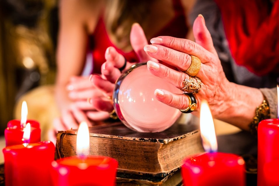 Female Fortuneteller sees in the future by looking into their crystal ball